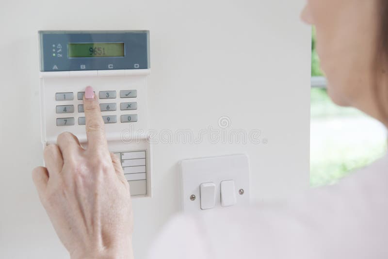 Woman Setting Control Panel On Home Security System stock photography