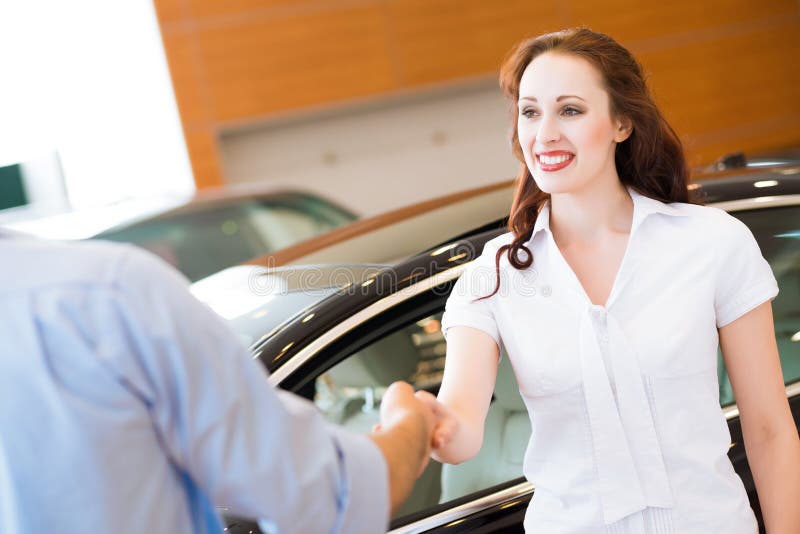 Woman shaking hands with car salesman