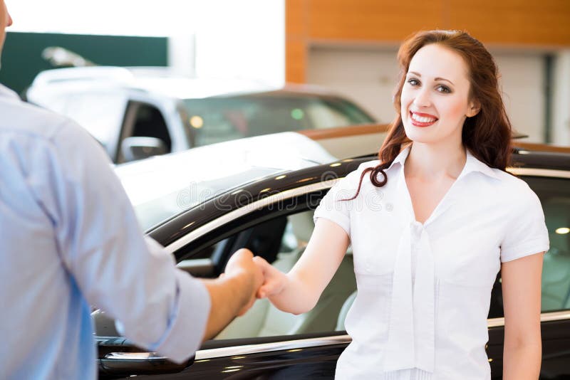 Woman shaking hands with car salesman