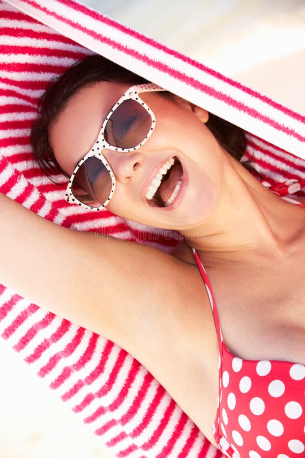 Woman Sheltering From Sun On Beach Holiday