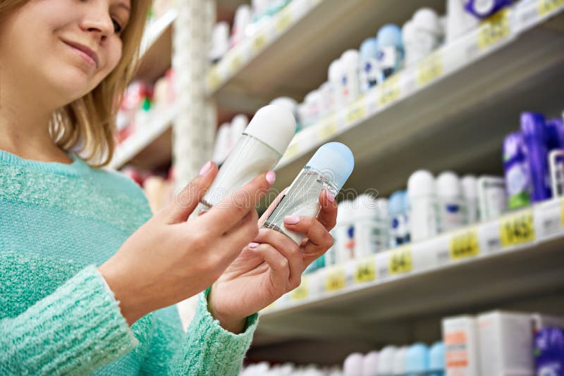 Happy woman in shop chooses deodorant