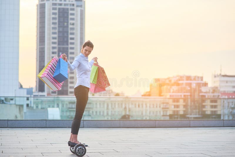 Woman with shopping bags, hoverboard.
