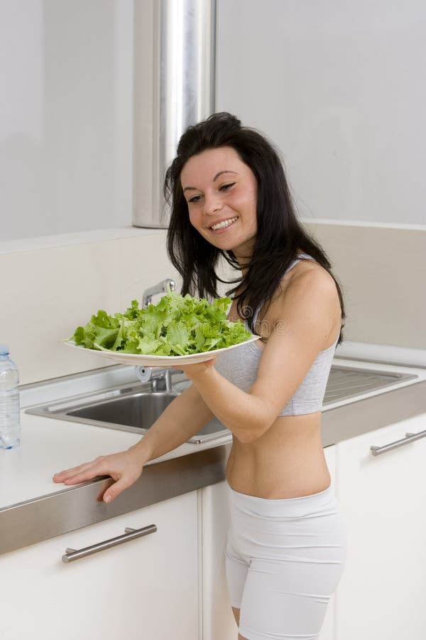 Woman showing salad in kitchen