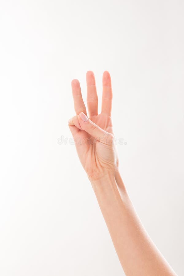 Woman showing three fingers: point, middle and ring ones. Woman showing her hand and arm over white background.