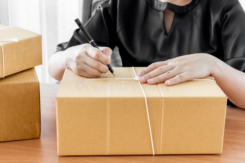 Woman signs papers among parcels stock images