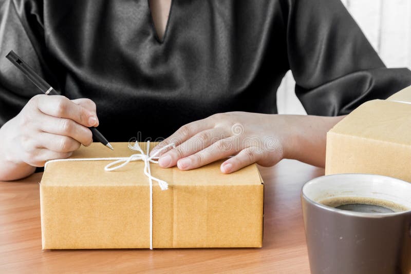 Woman signs papers among parcels royalty free stock image