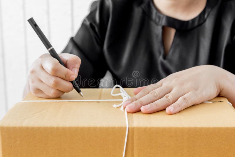 Woman signs papers among parcels royalty free stock photos