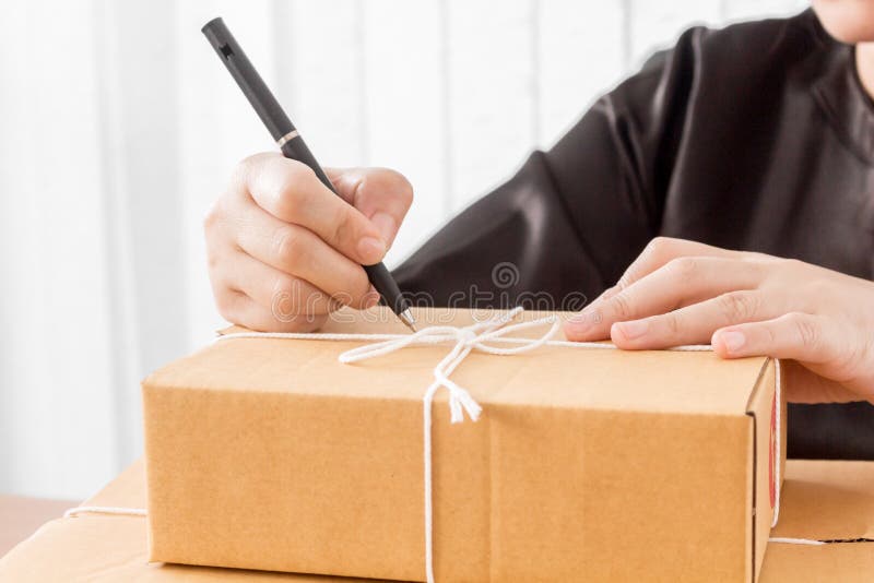 Woman signs papers among parcels royalty free stock photography