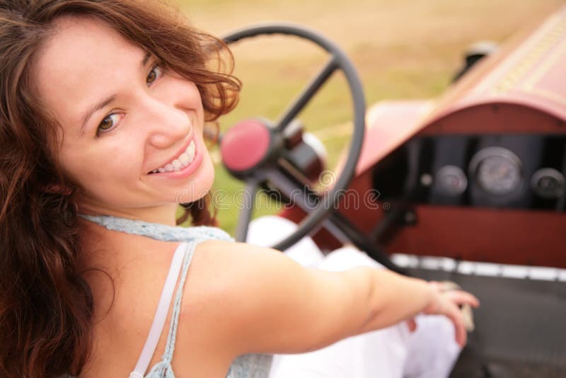 Woman sits in ancient car