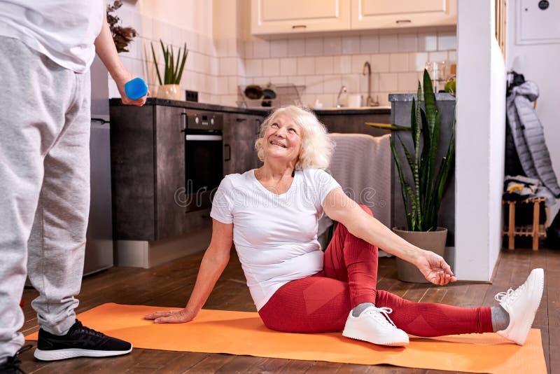 beautiful caucasian woman sits stretching on the floor while husband workout royalty free stock photos