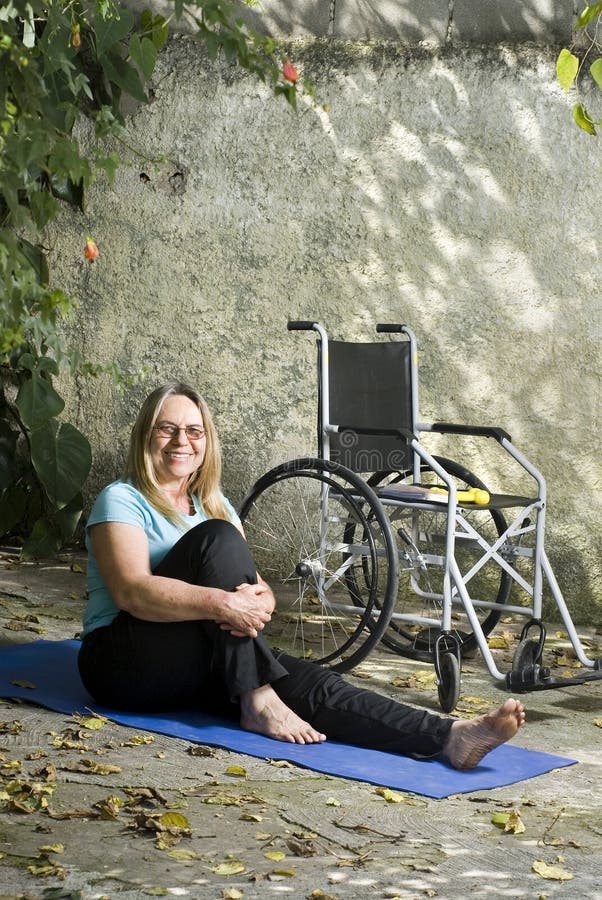 Woman Sits on Yoga Mat Smiling- Vertical