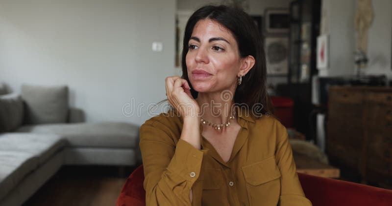 Woman sitting in armchair looks sad while thinking about problem stock video