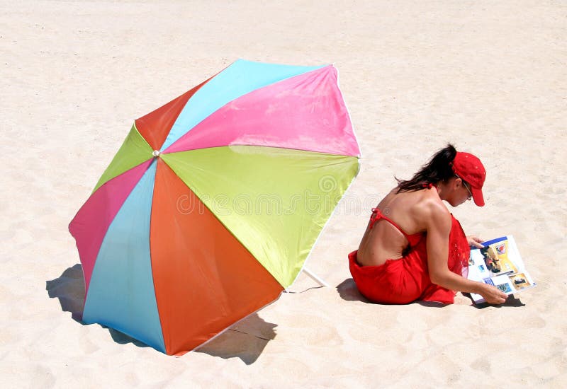 Woman sitting on beach reading