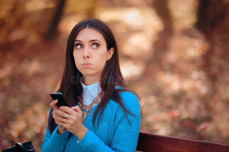 Woman Sitting on a Bench Receiving a Strange SMS stock image Woman Sitting on a Bench Receiving a Strange SMS stock image