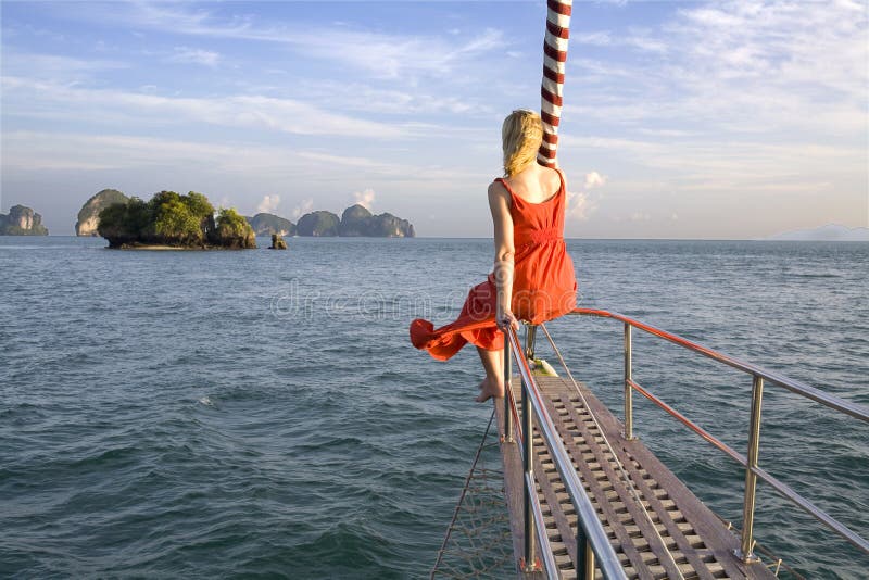 Woman sitting on bow of yacht