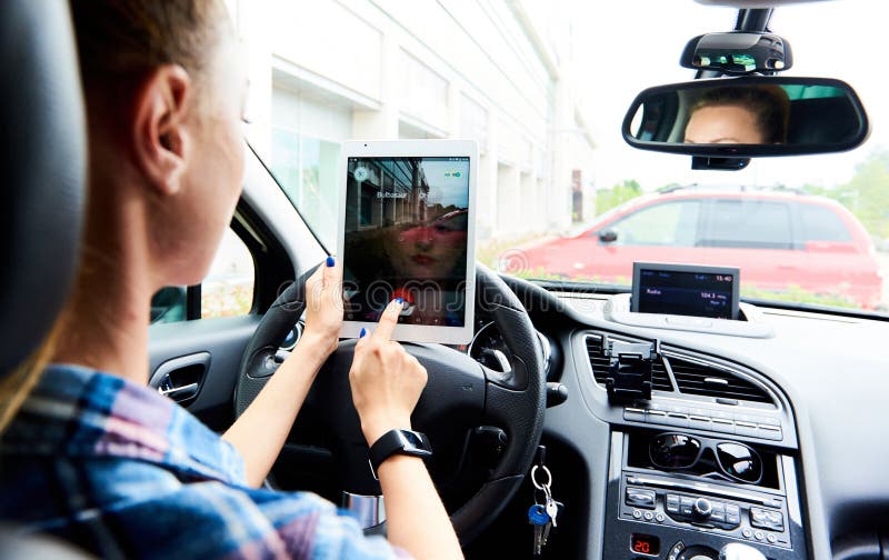 Woman sitting in a car and playing a Pokemon Go game Stock Photo - Alamy