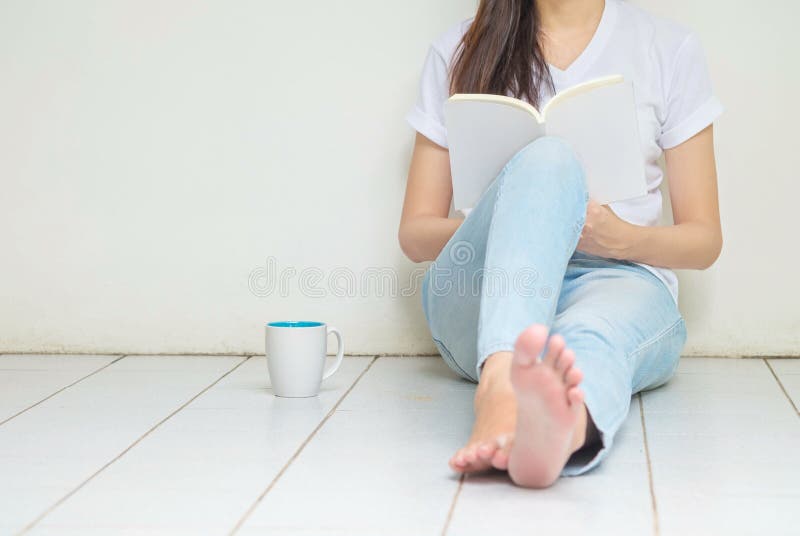 Woman sitting at the corner of house for reading a book in free time in the afternoon , relax time of asian woman