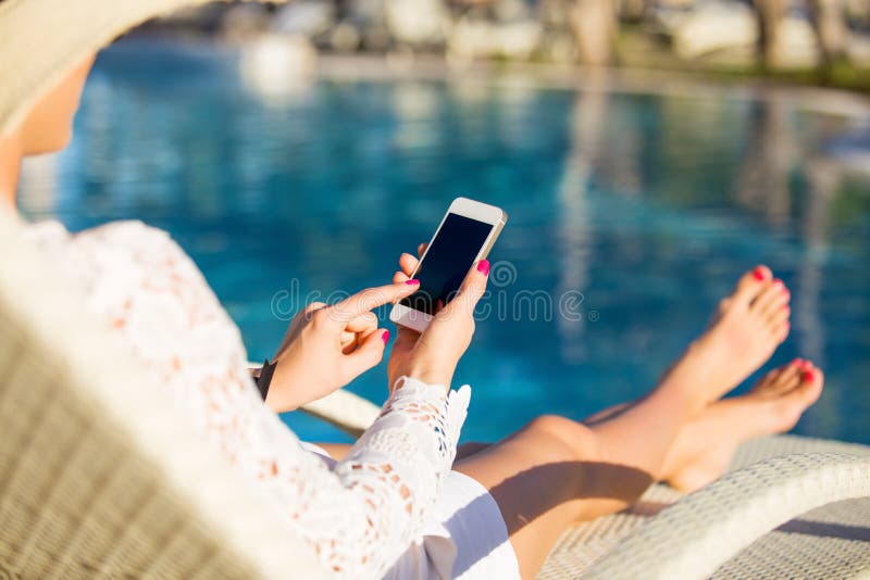 Woman sitting in deck chair and using mobile phone Woman sitting in deck chair and using mobile phone