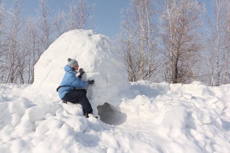The woman sitting at an entrance to an igloo stock photography The woman sitting at an entrance to an igloo stock photography