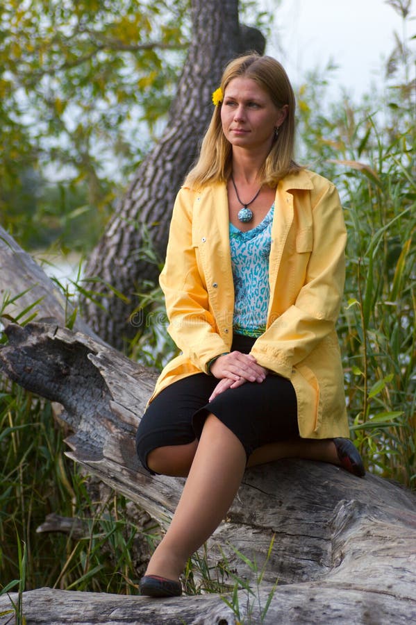 Woman sitting on fallen tree