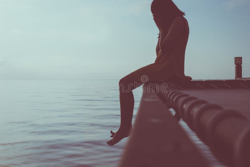 Woman sitting and feeling depression with having a headache at sea,Mental disorder health care,World suicide prevention day concep