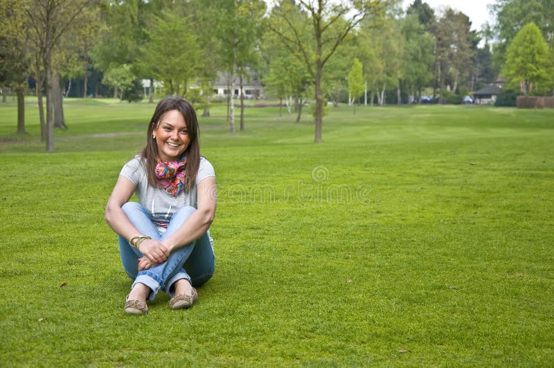 Woman sitting on a green grass