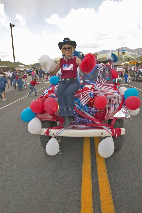 Woman sitting on the hood of a jeep decorated for the Fourth of July, in Lima Montana stock photography Woman sitting on the hood of a jeep decorated for the Fourth of July, in Lima Montana stock photography