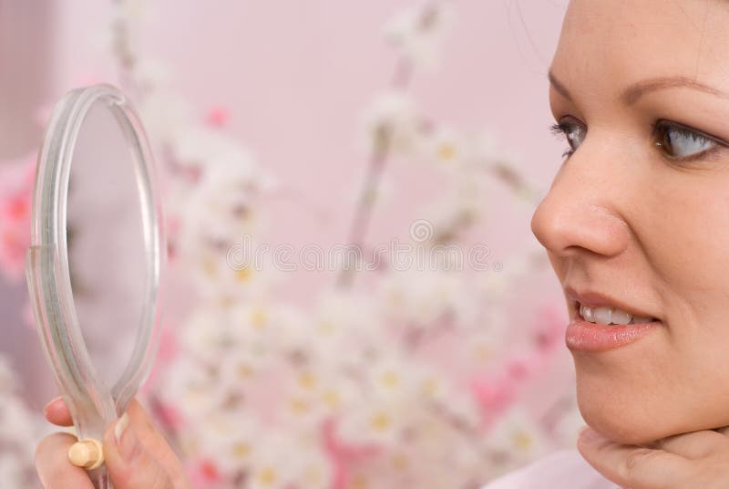 Woman sitting and looks in the mirror