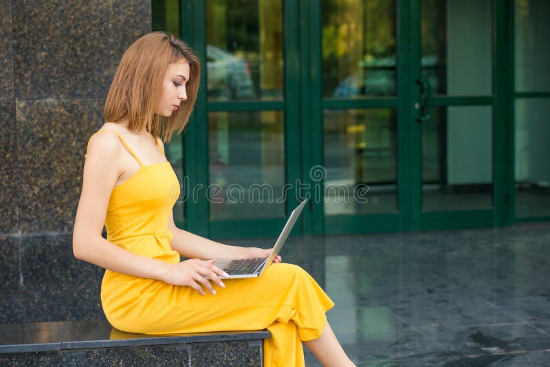Woman sitting outside, using laptop stock photography Woman sitting outside, using laptop stock photography