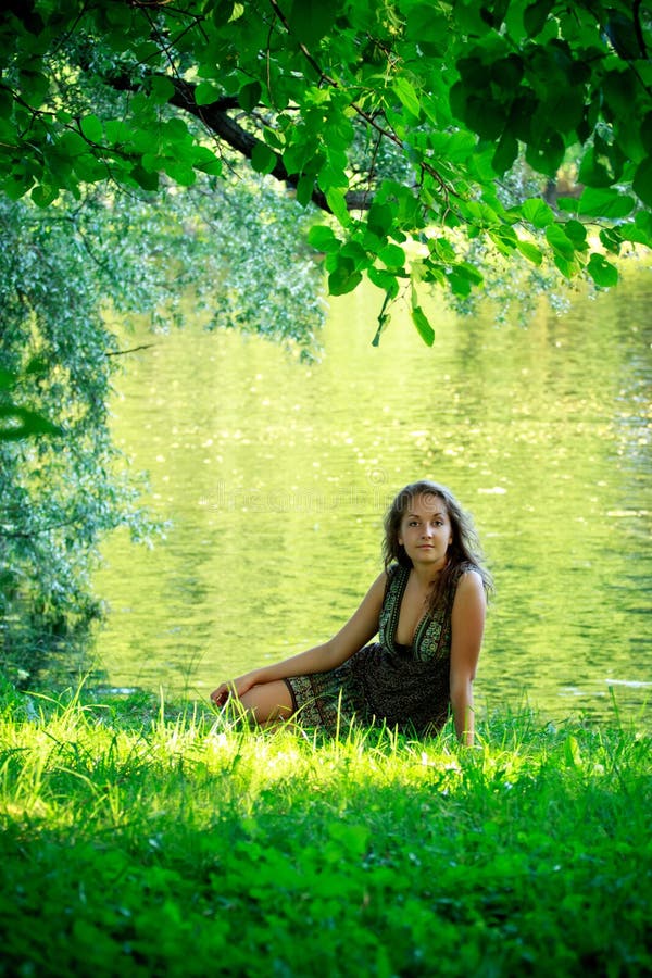 Woman sitting on riverside stock image. Image of reflection - 15379753