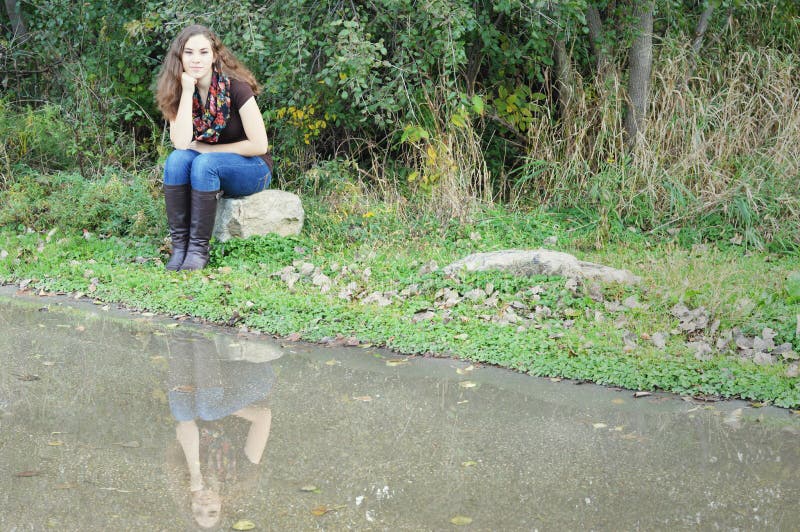 Woman Sitting on Rock Reflection royalty free stock images Woman Sitting on Rock Reflection royalty free stock images