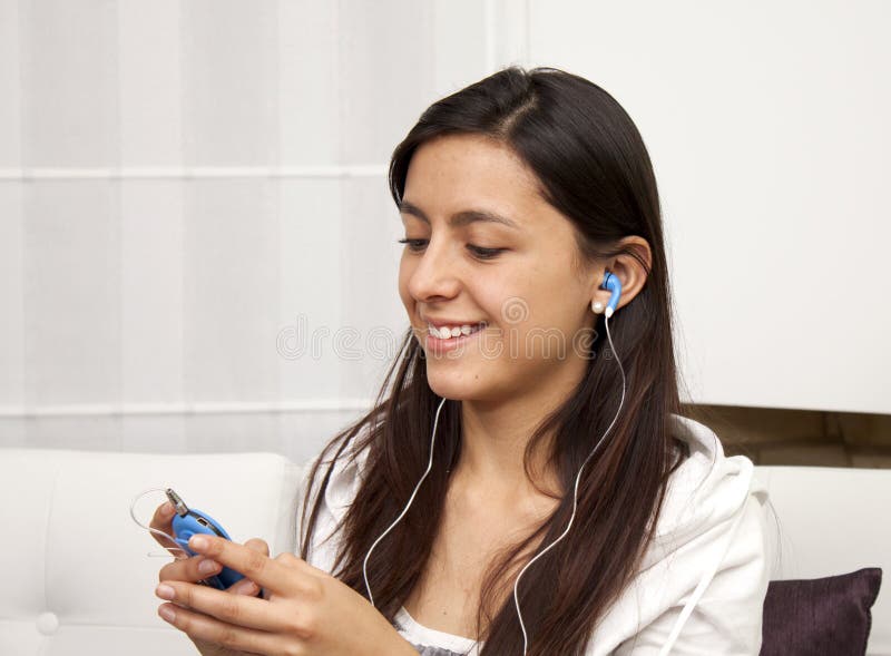 Woman sitting on sofa and listening to music