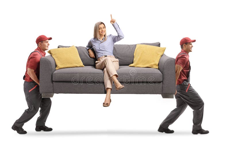Woman sitting on a sofa and pointing up while two workers from a removal company carry the sofa