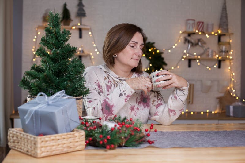 Woman sitting at a table and drinking hot chocolate royalty free stock photo