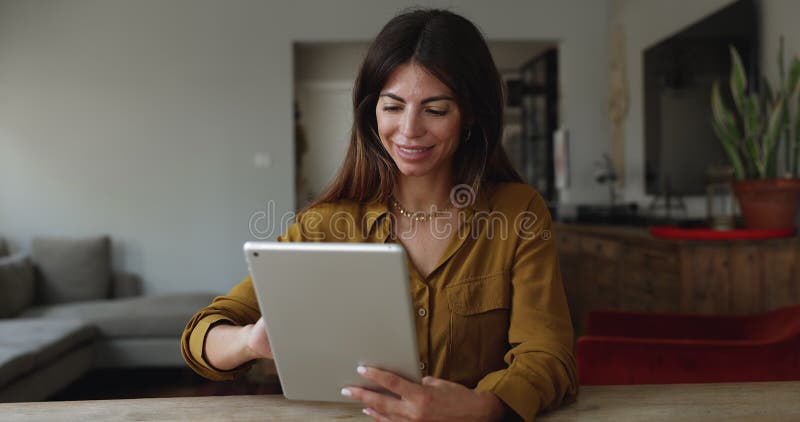 Woman sitting at table in living room using digital tablet stock footage