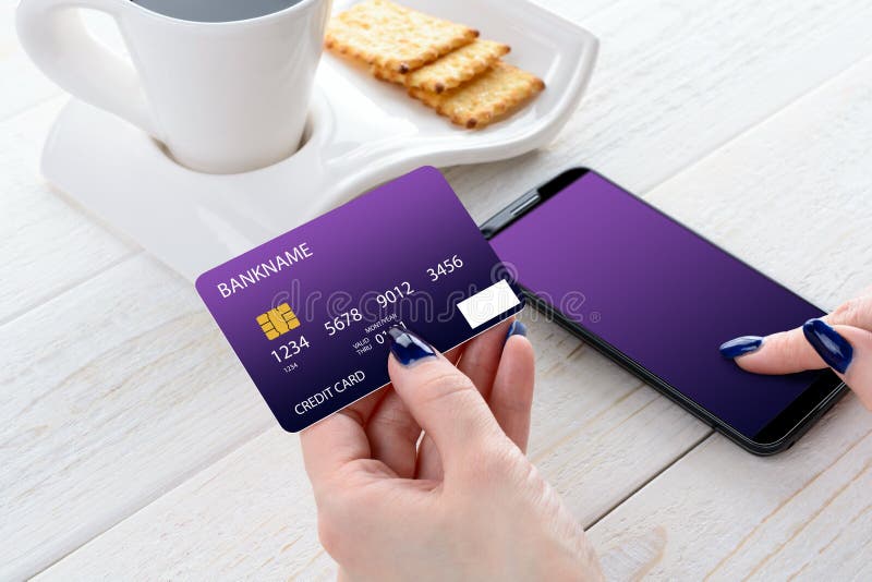 Woman sitting at table and pays the purchase through smartphone stock image Woman sitting at table and pays the purchase through smartphone stock image