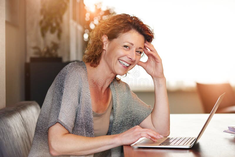Woman sitting at table with smiling with laptop royalty free stock photos Woman sitting at table with smiling with laptop royalty free stock photos