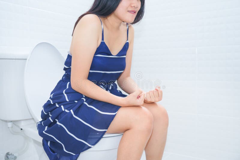 Woman sitting on toilet with hands fist - constipation concept.