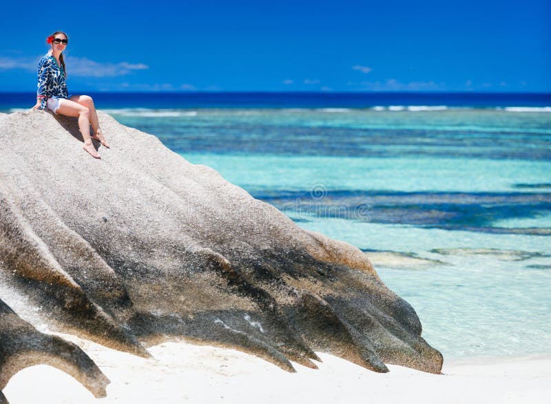 Woman sitting on top of granite rock stock image