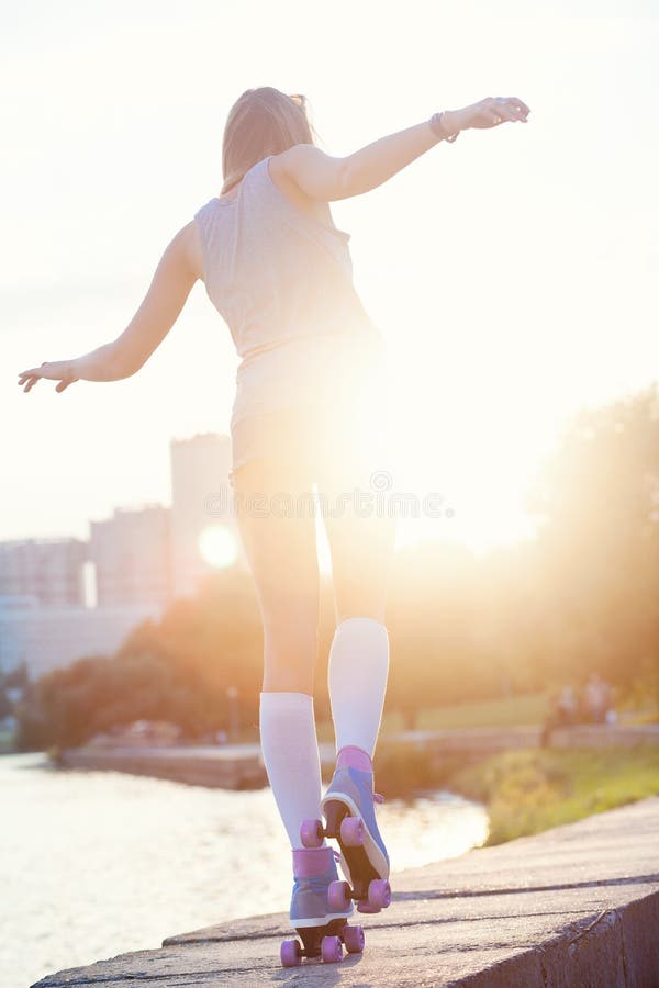 A beautiful caucasian roller skater woman during the sunset, outdoor. A beautiful caucasian roller skater woman during the sunset, outdoor