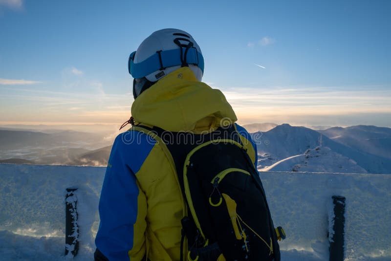 Žena lyžař při pohledu na západ slunce nad horami Slovenska