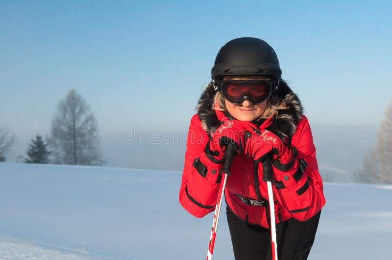Woman skier in the mountains in red winter jacket royalty free stock photo