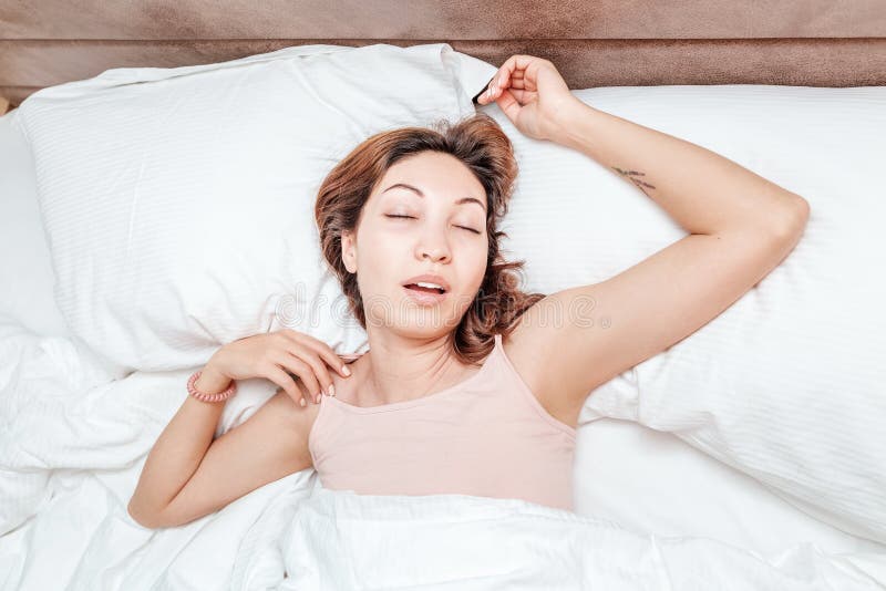 Woman sleeps relaxed on a large spacious bed at home or in a hotel stock image Woman sleeps relaxed on a large spacious bed at home or in a hotel stock image