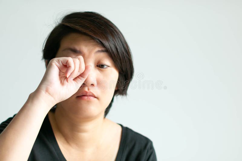 Woman in sleepy face is rubbing her eye