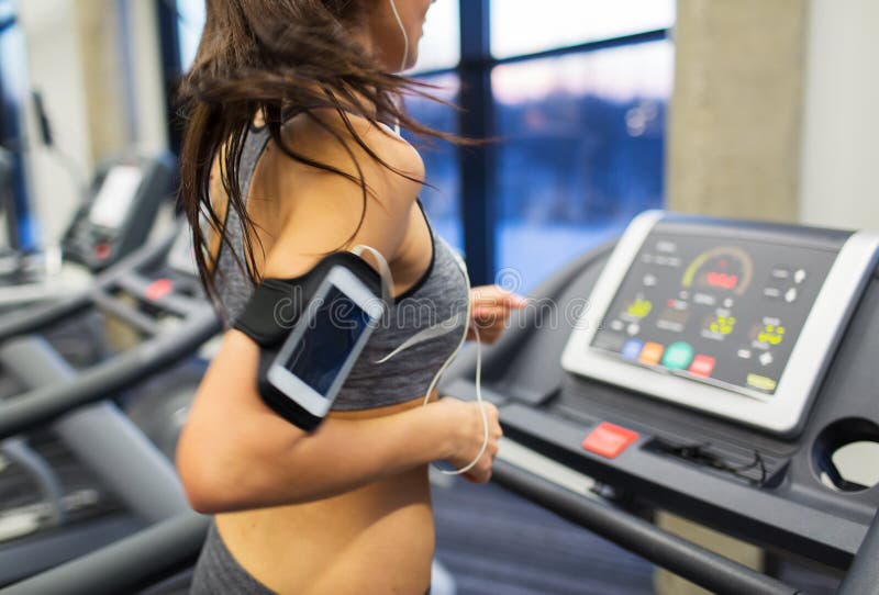 Woman with smartphone and earphones in gym