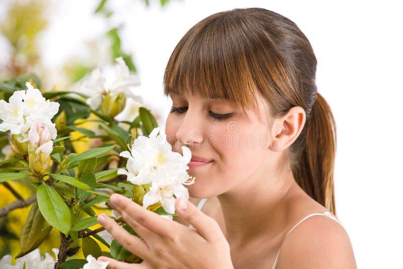 Woman smelling blossom of Rhododendron flower