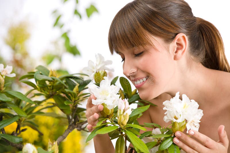 Woman smelling blossom of Rhododendron flower