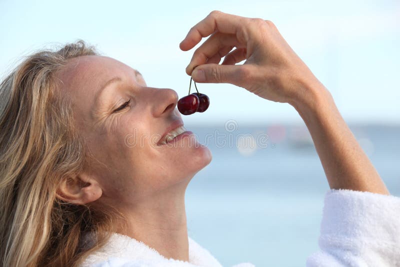 Woman smelling cherries stock photo