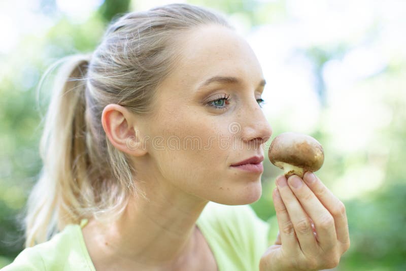Woman smelling mushroom stock photos
