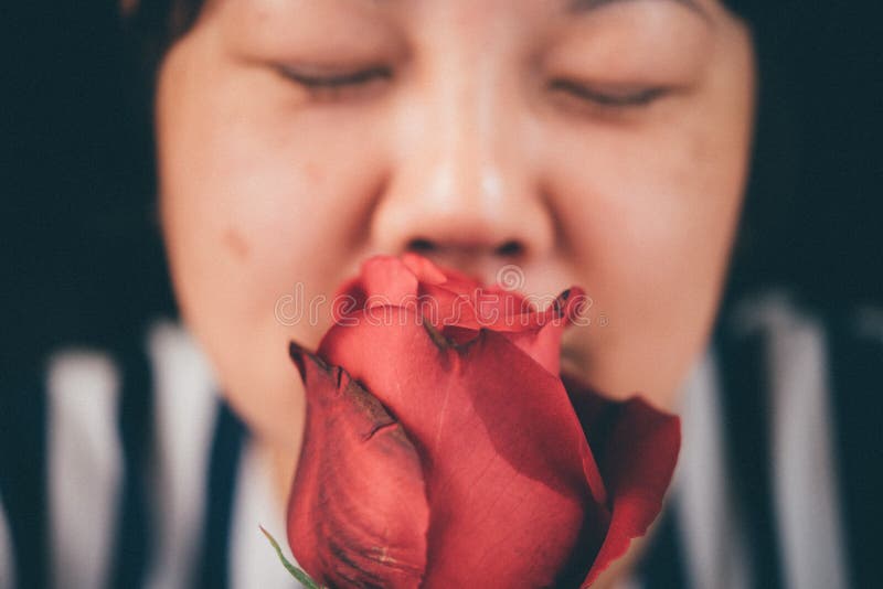 Woman smelling Red rose flower in Valentine`s Day